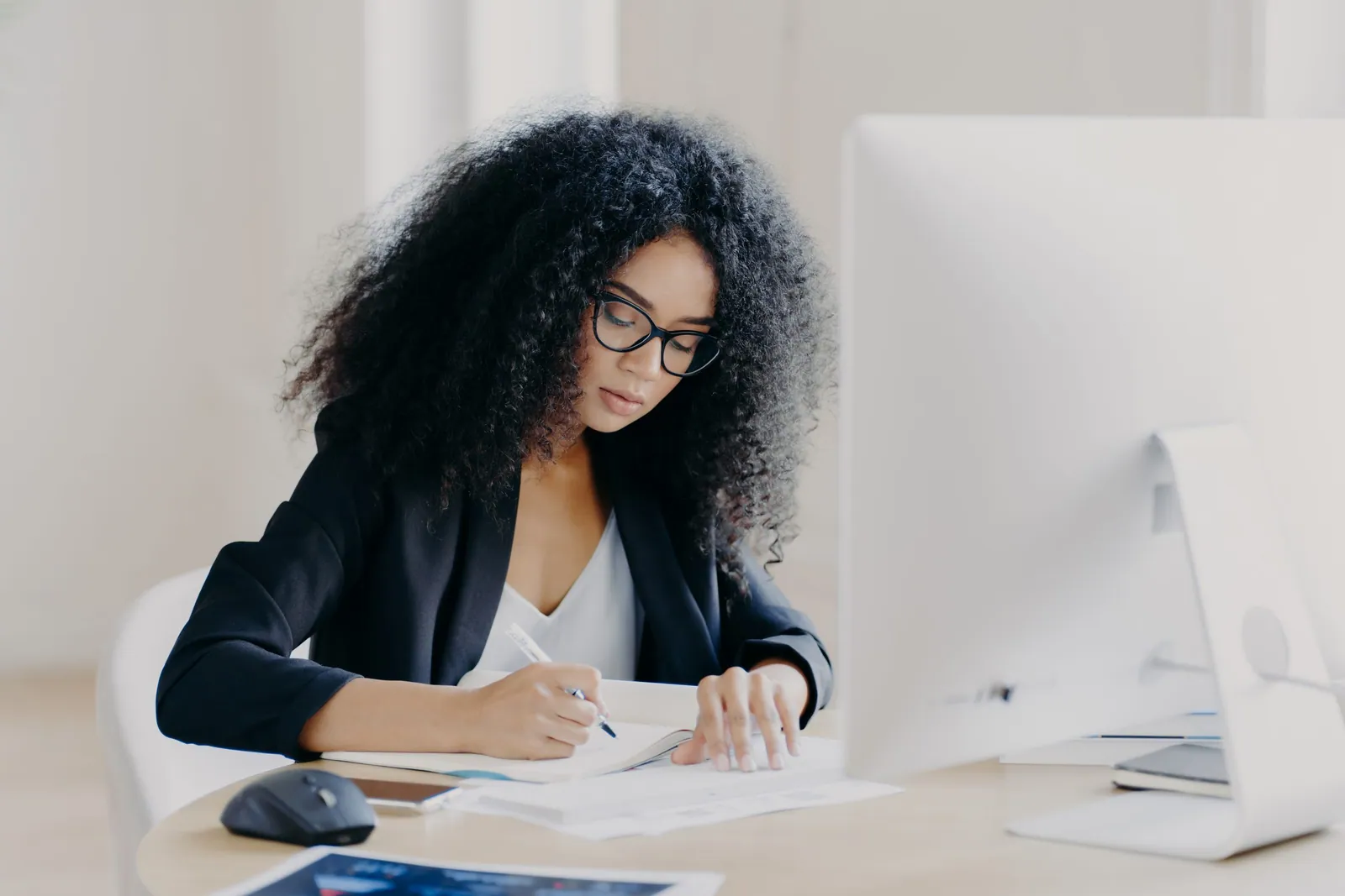 serious afro woman writes in papers sits at table 2022 12 03 22 16 20 utc